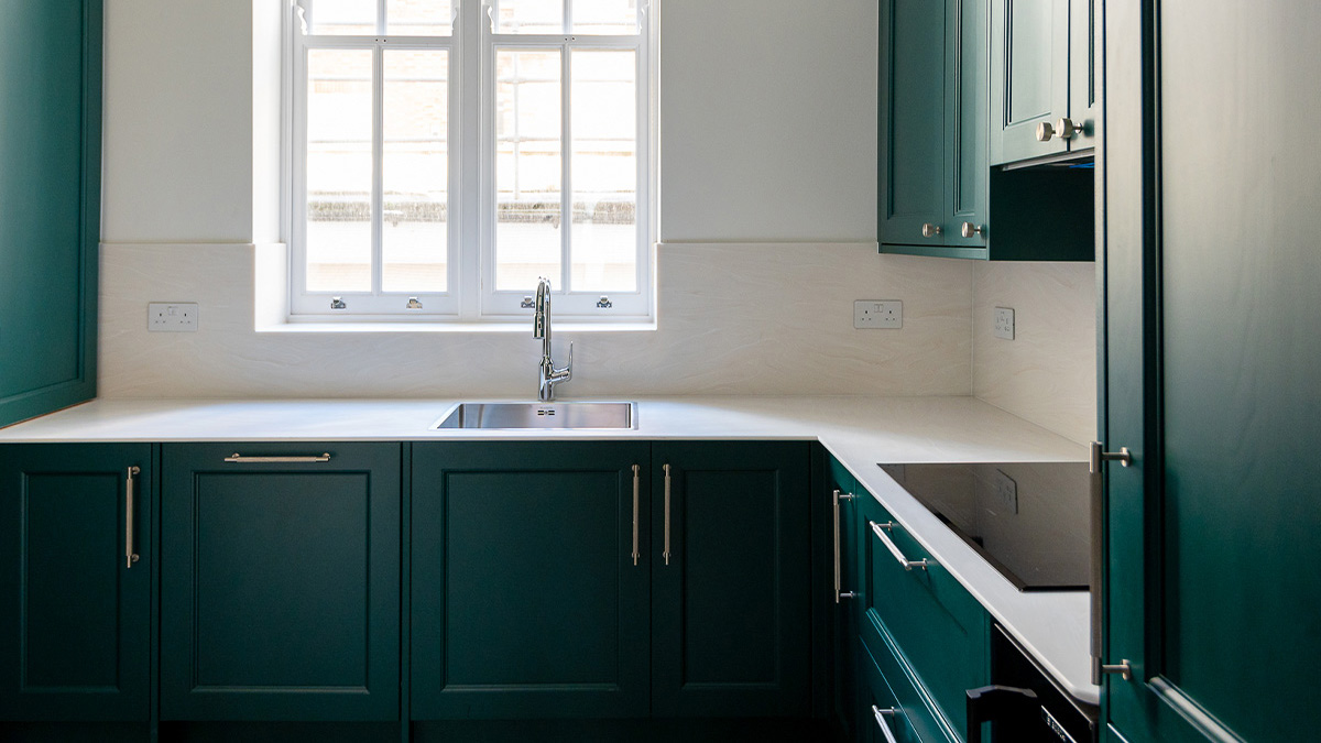 Vibrant basil green kitchen cabinets with white countertops