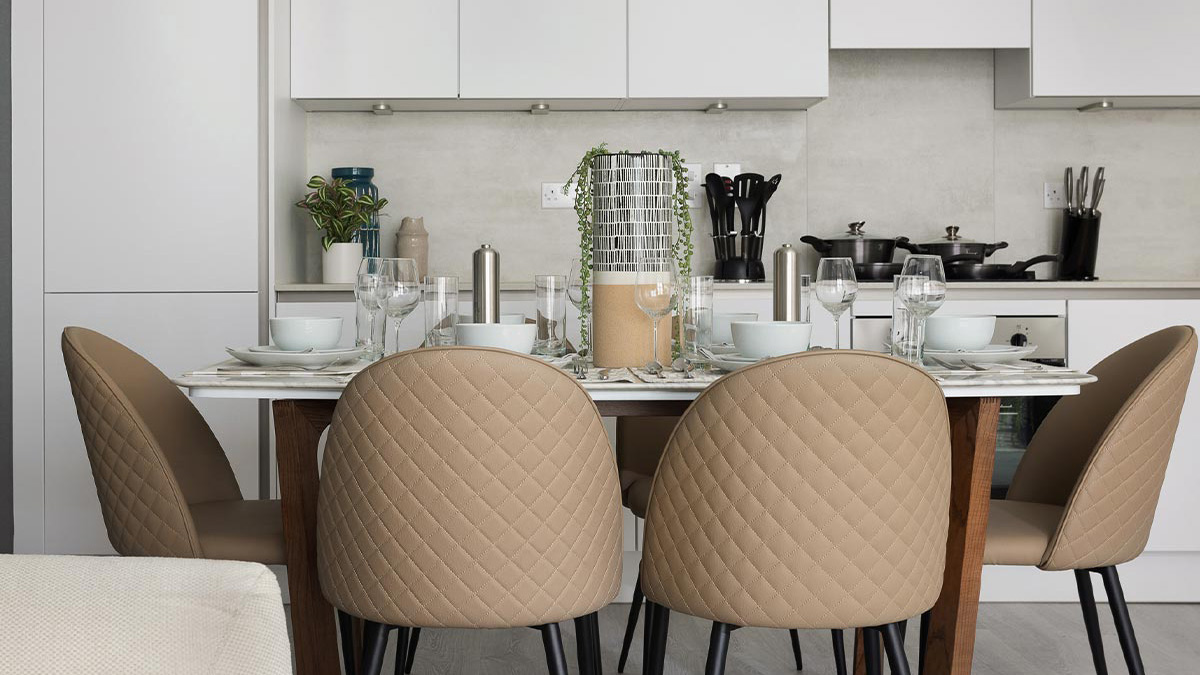 Modern dining area with quilted beige chairs and white table