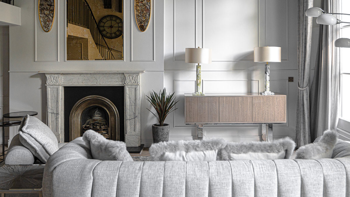 Luxury grey sofa in elegant living room with fireplace