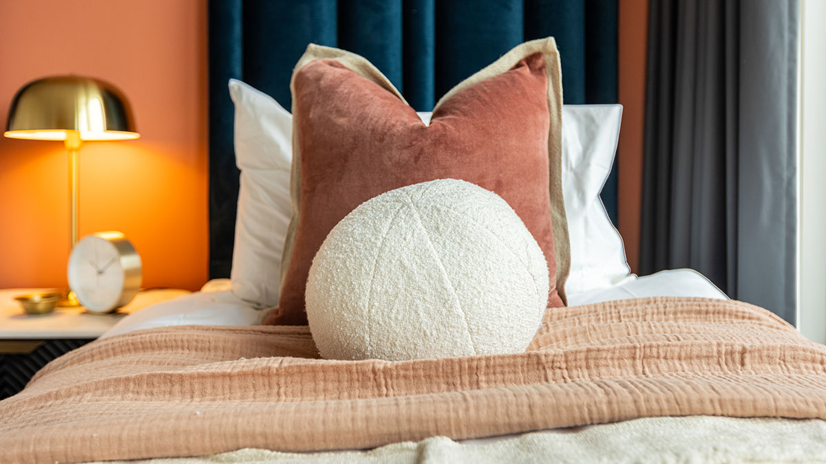 Vibrant terracotta bedroom transformation for London flat, highlighting premium furnishing packages for investors