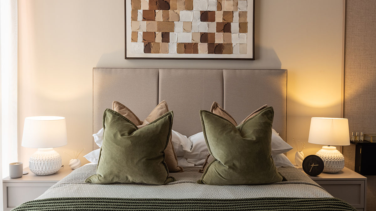 Modern bedroom with upholstered headboard and designer furnishings at West End Gate